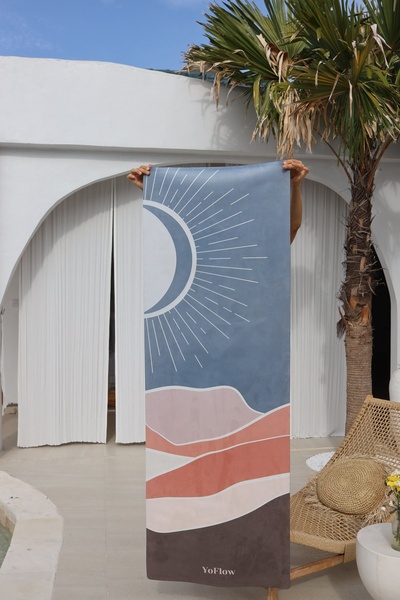 A high-quality lifestyle shot featuring a held-up yoga mat against a bright, architectural backdrop to emphasize its design and color palette.